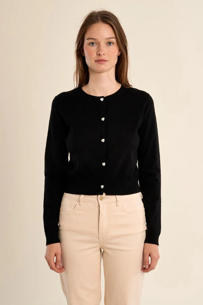 Black slim-fit knitted cardigan with heart button closure and khaki pants - front view.