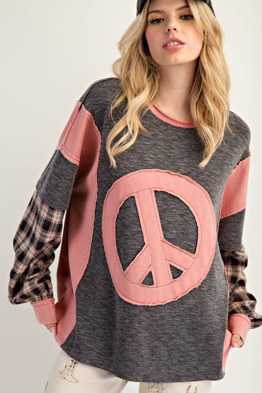 Mineral-washed thermal pullover with a large pink peace patch, plaid layered sleeves, and relaxed fit.