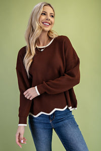Knit sweater with contrast-colored hem and wavy edge detail.