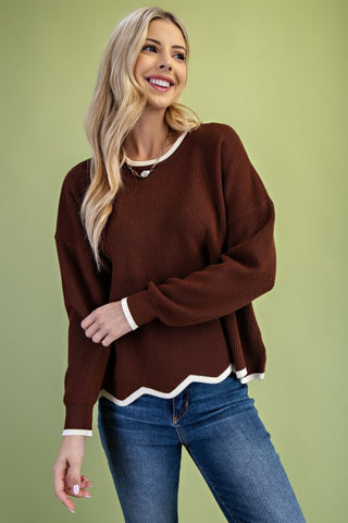 Knit sweater with contrast-colored hem and wavy edge detail.