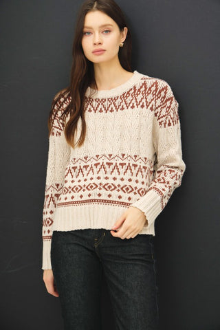 Cream and rust Fair Isle cable knit sweater with drop shoulders and a relaxed fit.