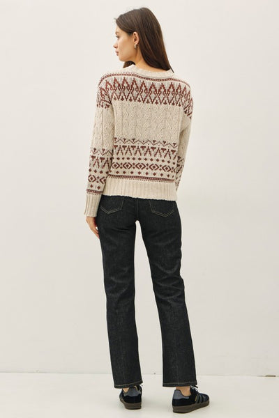 Cream and rust Fair Isle cable knit sweater with drop shoulders and a relaxed fit.
