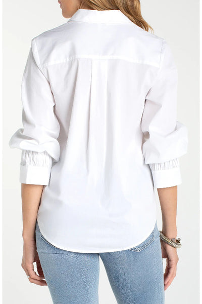 Back view of white Liverpool Adjustable Sleeve Button Front Woven Top showing curved shirttail hem and scrunched sleeves, styled with light wash jeans.