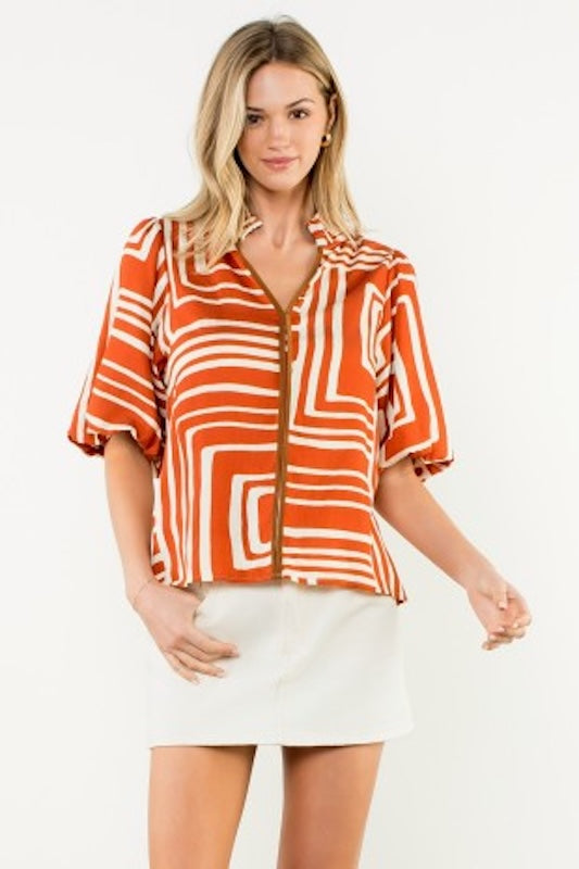 Abstract puff sleeve blouse in Rust color with contrast trim.
