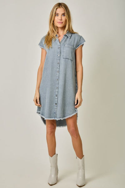 Flutter Sleeve Tencel Shirt Dress with Fringe Hem in light denim blue, front view showing button-front closure, flutter sleeves, hi-lo silhouette, and fringe hem with white boots.