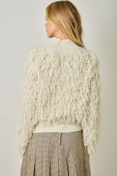 Back view of the Mystree ivory shaggy knit sweater showing textured long sleeves, ribbed mock neck, and ribbed hem. Mystree ivory sweater; Mystree shaggy knit sweater; ivory mock neck sweater; women's shaggy pullover sweater; textured ivory sweater; long sleeve mock neck sweater; ivory fall sweater for women; women's neutral winter sweater; Mystree 61640 sweater; ivory sweater with ribbed hem