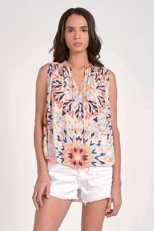 Sleeveless multi-color kaleidoscope floral top with flowy fit and ruffled V-neck.