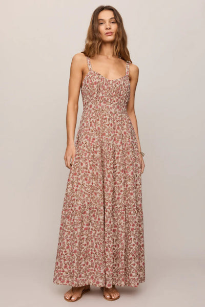 Model is wearing a floral dress with flat sandals.