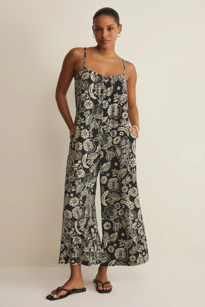 Black Day Off Luz floral print sleeveless jumpsuit with ruffle scoop neckline, adjustable spaghetti straps, and wide straight leg, front view.