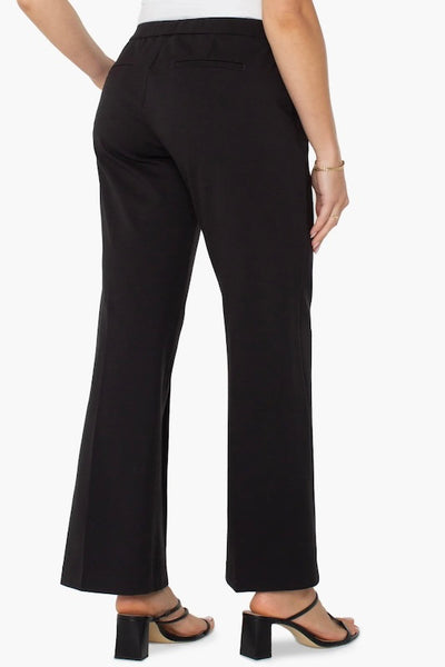 Back view of black wide-leg pull-on pants with elastic waistband and welt pockets.