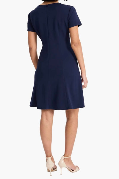 Maggy London navy short sleeve fit and flare dress with goldtone brooch at gathered crewneck, back view.