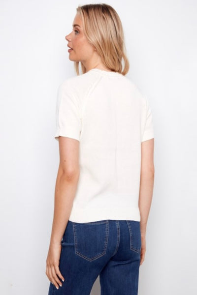 Model wearing a white t-shirt with a lemon graphic design paired with denim.