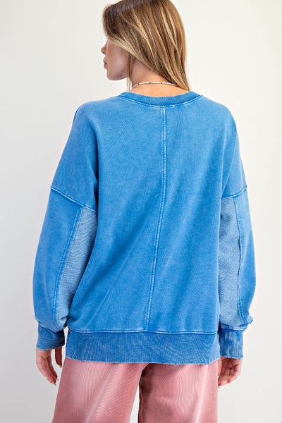 Blue mineral washed terry pullover with crew neckline, triangle stitch detail, and long sleeves.