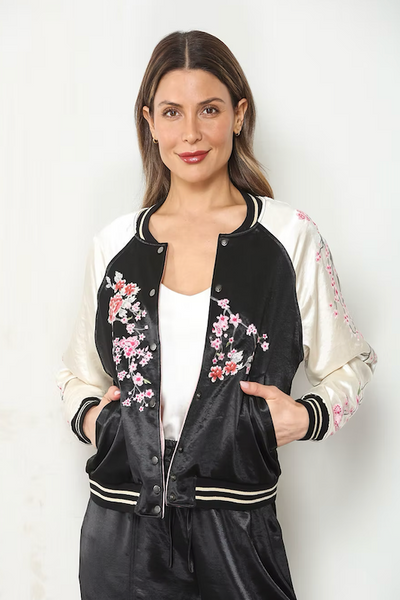 Model wearing the embroidered black-and-cream side of a reversible cherry blossom satin bomber jacket, front view;Paparazzi reversible bomber jacket
cherry blossom embroidered bomber jacket
reversible satin bomber jacket women
black and cream floral bomber jacket
blush pink satin bomber jacket
embroidered floral jacket women
hammered satin bomber jacket
pink cherry blossom jacket
women’s reversible floral jacket
satin bomber jacket with embroidery