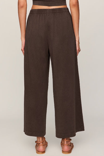 Z Supply Scout Jersey Crop Flare Pant in dark chocolate, wide-leg silhouette, elastic waistband, mineral wash cotton, cropped length — back view styled with strappy sandal.