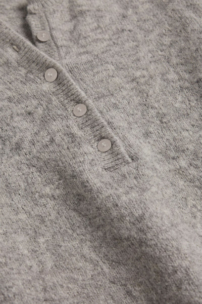 Close-up of gray Z Supply Westmont Henley Sweater showing its button placket and textured knit. Z Supply Westmont Henley Sweater; Z Supply ZW264787; women's gray Henley sweater; women's button placket sweater; long sleeve knit Henley; cozy gray knit pullover; women's raglan sleeve sweater; cropped Henley sweater; relaxed fit Henley sweater; Z Supply women's knitwear.