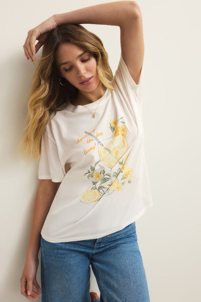 White Spritz Boyfriend Tee with yellow lemon graphic and 'Squeeze the Day Away' script, styled with blue jeans in relaxed fit.