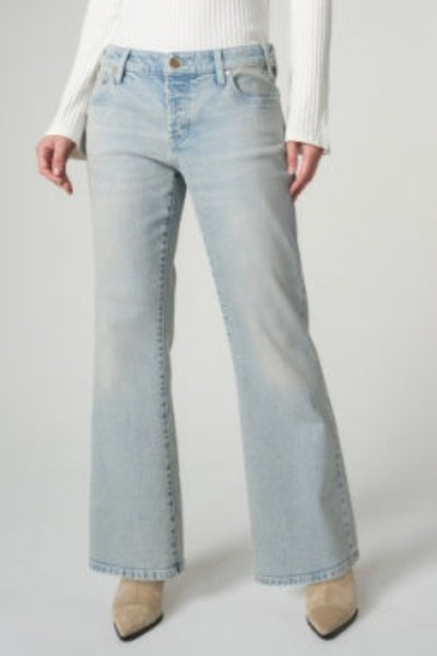 Model is wearing Liverpool Dakota Low Rise Loose Flare Jeans in Prairie Mist light-wash denim with wide flare leg, front view, styled with white knit top and tan heels.