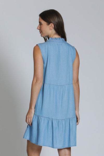 Back view of the Tencel Sleeveless Dress With Split Neck in light blue, showing the ruffle collar neckline detail, tiered skirt, and relaxed silhouette