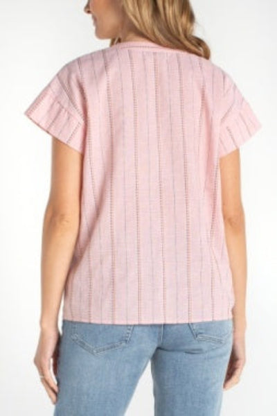 Pink multi-stitch popover top with chevron stitching detail, back view, paired with blue jeans.