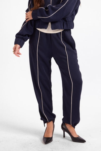 Model wearing Sage the Label navy and ivory tapered jogger pants;Sage the Label Bike Ride Joggers
Sage the Label navy joggers
women’s navy and ivory joggers
navy joggers with ivory piping
women’s tapered jogger pants
women’s pull-on track pants
women’s matching track set
lined polyester joggers for women
sporty chic navy pants
relaxed-fit ankle joggers