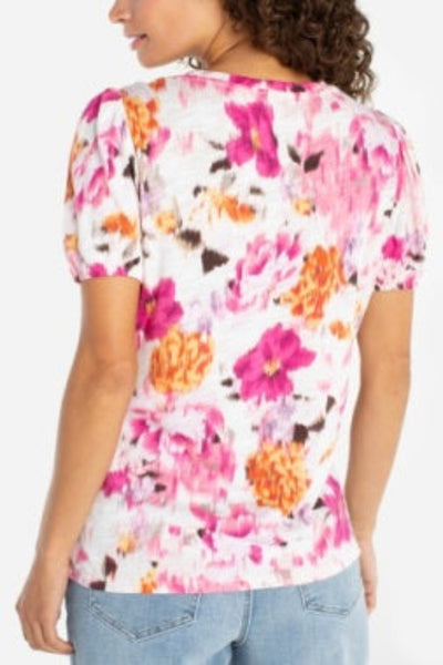 Multicolor floral puff sleeve knit top with pink and orange blooms, scoop neckline, back view, paired with blue jeans.