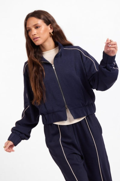 Close view of Sage the Label navy track jacket with ivory contrast piping;Sage the Label Bike Ride Track Jacket
Sage the Label navy track jacket
women’s navy and ivory track jacket
women’s cropped track jacket
navy jacket with ivory piping
sporty chic jacket for women
women’s matching track set
relaxed fit zip-front jacket
women’s boutique athleisure jacket
navy cropped lightweight jacket