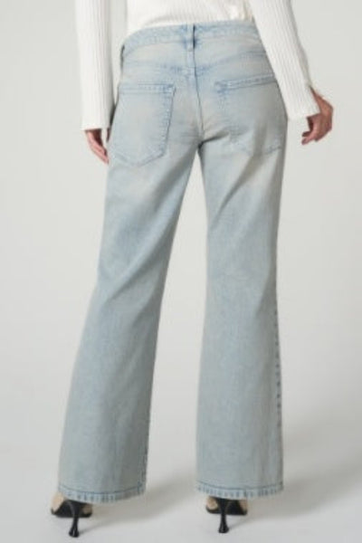Back view of Liverpool Dakota Low Rise Loose Flare Jeans in Prairie Mist showing five-pocket styling and wide flare leg, styled with white knit top and black heels
