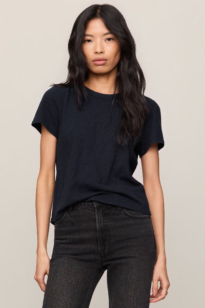 Model is wearing a black t-shirt and dark jeans, front view. 


